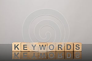 Wooden cubes with word KEYWORDS on grey background. Space for text