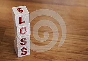 Wooden cubes with word LOSS on wooden table. Financial loss or unprofitable busines ventures concept