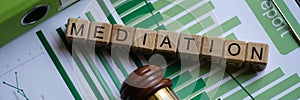 Wooden cubes with word mediation and judge gavel on documents