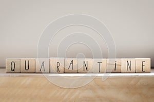 Wooden cubes with the word quarantine concept represented by wooden letter tiles, virus concept