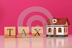 Wooden cubes with word TAX and house model