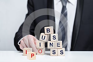 Wooden cubes with words business and IPO, business IPO concept, businesman in suit