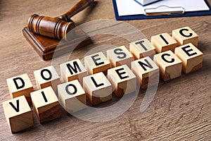 Wooden cubes with words DOMESTIC VIOLENCE on wooden table