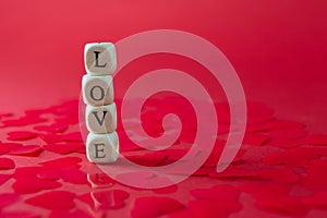 Wooden cubes with the words LOVE on a red background. Valentine`s Day concept