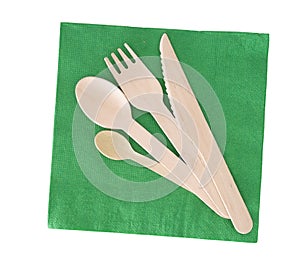 Wooden cutlery, fork, spoon, knife with green paper napkin isolated on white.