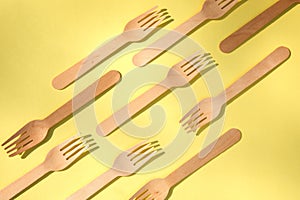 A wooden cutlery on a yellow background. Eco friendly, zero waste concept