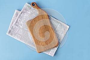 Wooden cutting board on cotton tablecloth napkin