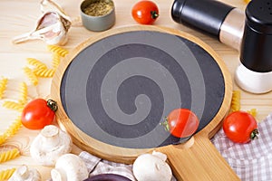 Wooden cutting board and fresh ingredients for cooking over wooden table background, close-up