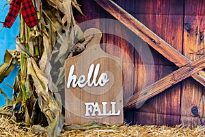 Wooden cutting board with `Hello Fall` text on it