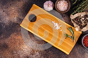 Wooden cutting board with herbs and spices.