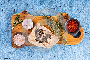 Wooden cutting board with herbs and spices.