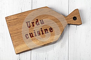 Wooden cutting board with inscription. Concept of urdu cuisine