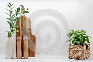 Wooden cutting board, kitchenware and plant in basket