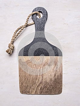 Wooden cutting board with a rope on the handle with text area wooden rustic background top view close up