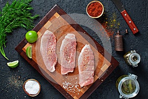 Wooden cutting board with three pieces of pork schnitzel