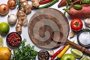 Wooden cutting board, wooden spoon, vegetables and spices
