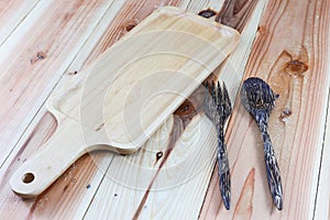 Wooden cutting boards, wooden spoons, wooden forks on wood background