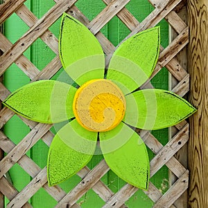 Wooden daisy decoration on trellis