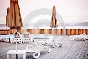 Wooden deck beach sea ocean resort sun lounger umbrella hotel pool sky sunrise.