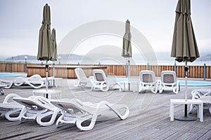 Wooden deck beach sea ocean resort sun lounger umbrella hotel pool sky sunrise.