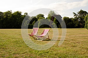 Wooden deck chairs on the lawn in the sun