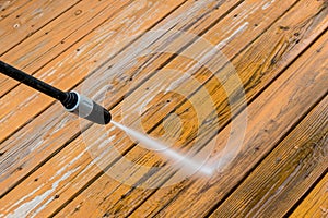 Wooden deck floor cleaning with high pressure water jet. photo