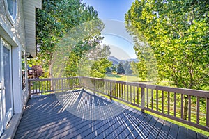 Wooden deck of a house with a beautiful view of green fields and trees at Utah Valley