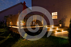 Wooden deck and patio of family home at night. photo