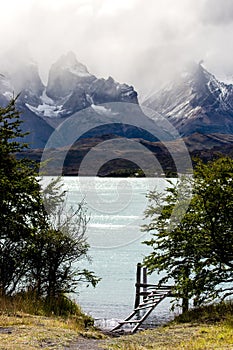 Wooden deck before turquoise Lake Pehoe and the Majestic Cuernos del Paine Horns of Paine