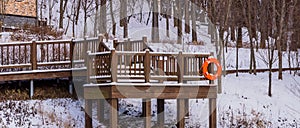 Wooden deck in a wooded area covered in snow