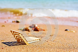 Wooden deckchair on a tropical sand beach.