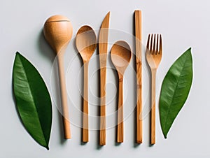 Wooden decomposable forks, spoons and knives on a light surface photo