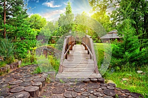 Wooden decorative bridge in the estate with landscaping in day