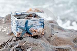 Wooden decorative Chest with sea shells and blue star on the sea coast