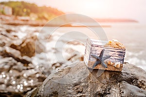 Wooden decorative Chest with sea shells and blue star on the sea coast