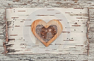 Wooden decorative heart on the birch bark
