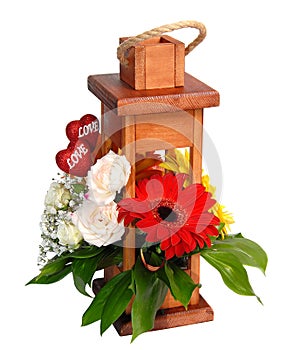 Wooden decorative lantern with flowers over white.