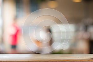 Wooden desk with Blurred of coffe`s shop for abstract background photo