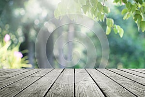 Wooden desk and blurred garden green nature background.