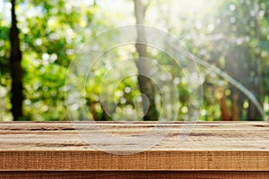 Wooden desk and blurred garden nature bokeh background.