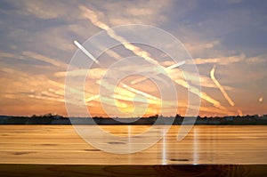 Wooden desk with blurred sunrise background