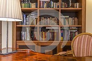 Wooden desk and classic bookcase with books