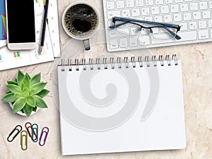 Wooden desk with Coffee cup,keyboard,smartphone,pencil and glasses