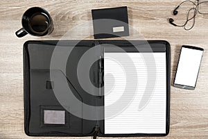 Wooden desk with smartphone, headphones, wallet, coffee mug and