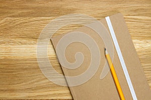 Wooden desk top with notebook and pencil