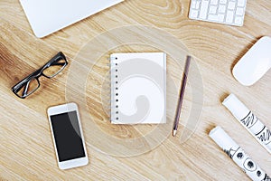 Wooden desktop with smartphone and notepad