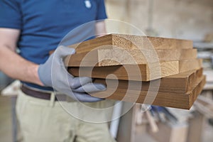 Wooden details in hands of male carpenter, woodworking industry