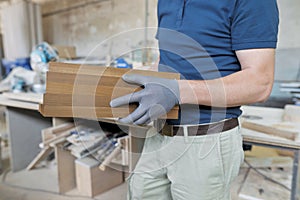 Wooden details in hands of male carpenter, woodworking industry