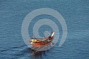 A wooden Dhow Sails into the Dubai Creek at dawn