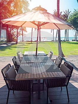 Wooden dining table and chairs with beach umbrella with sea view